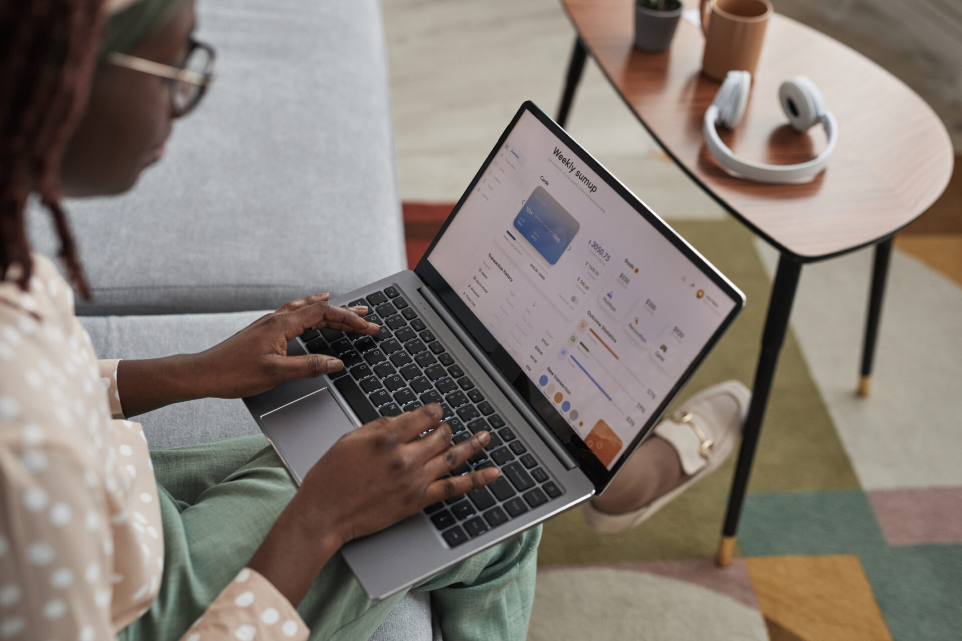 High angle view at young African-American woman using laptop with banking service on screen, copy space